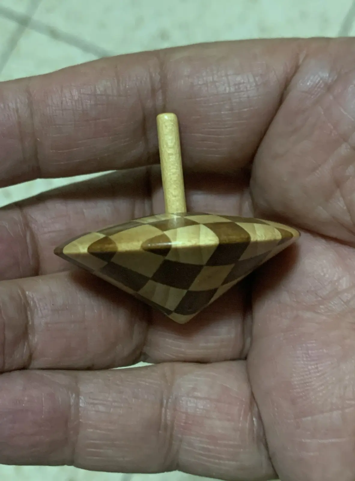 A spinning top made of intertwined maple (cherry) and walnut wood