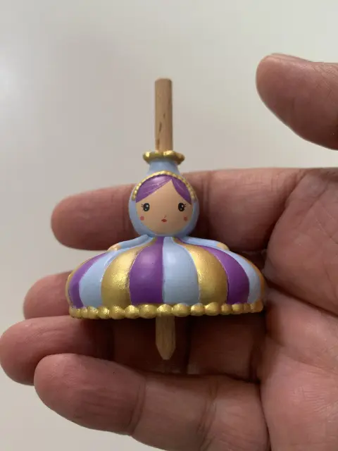 The Princess Spinning Top features touches of gold paint on wood. Designed by Virginie Brachet