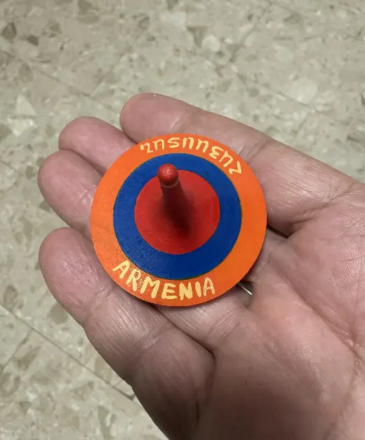 Armenian wooden spinning top with the colors of the flag