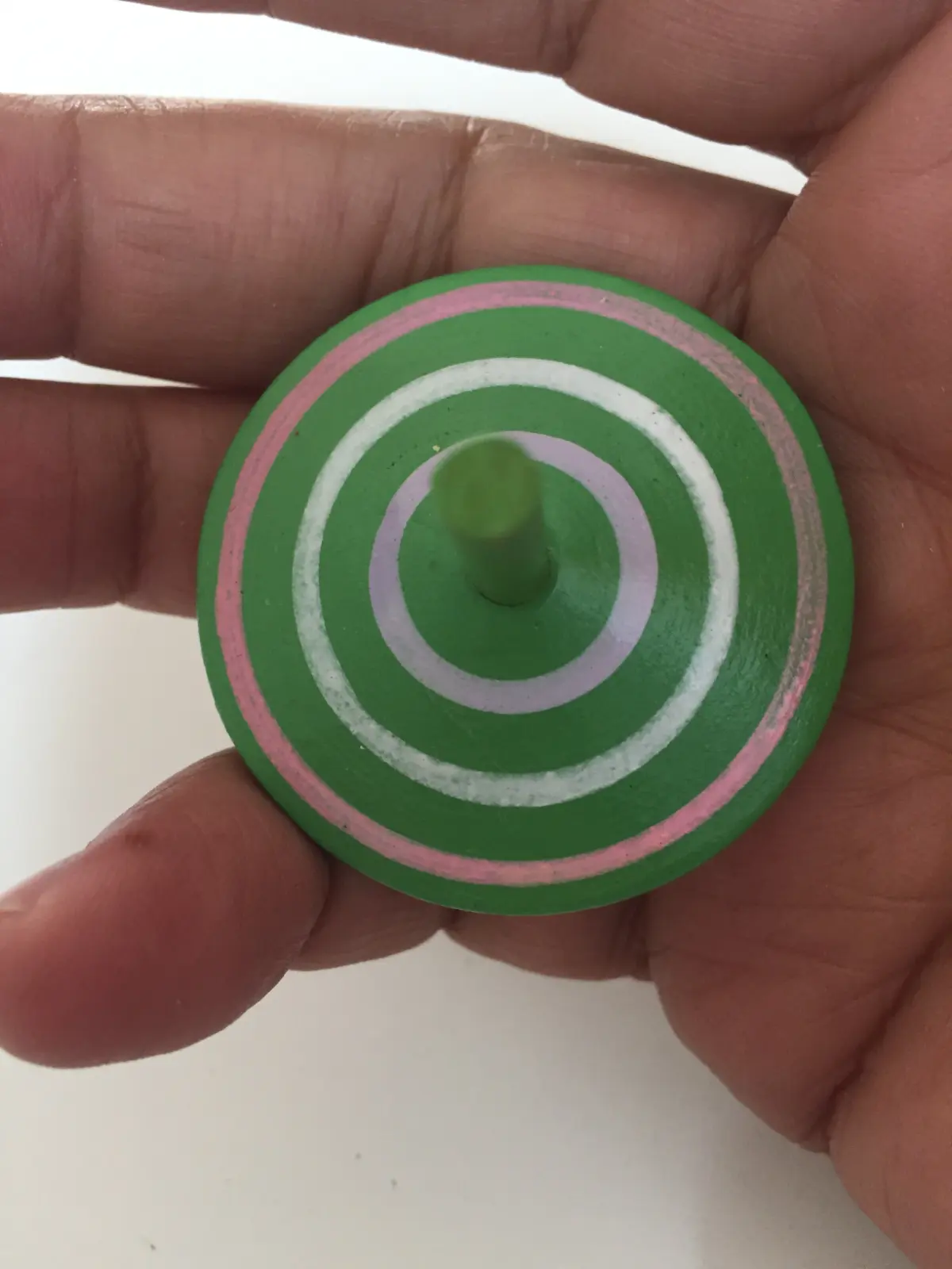Green spinning top with white and pink circles, Hungary