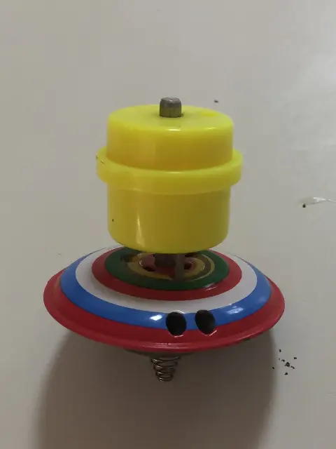סביבון מפח עם קצה קפיצי ומשגר צהוב קפיצי