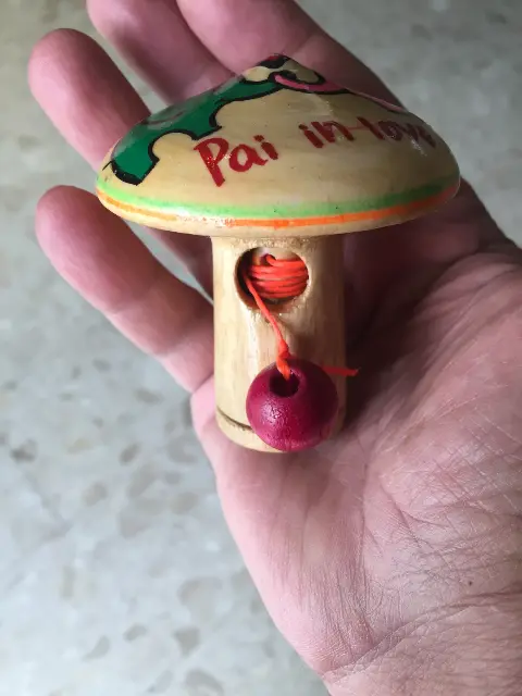 A spinning top with a launcher and a painting of two elephants and a heart from Thailand