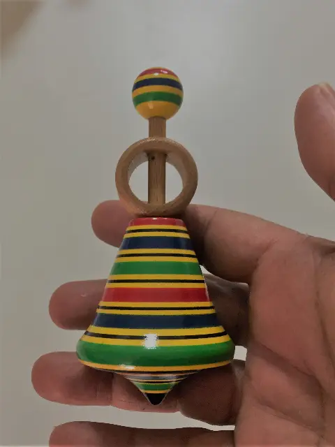 Spinning top with colorful rings, red, yellow, blue and green, with a launcher ring and string from Prague, Czech Republic