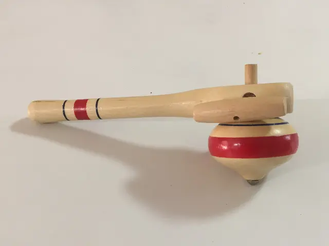 Red and natural wood spinning top with wooden launcher from Prague, Czech Republic